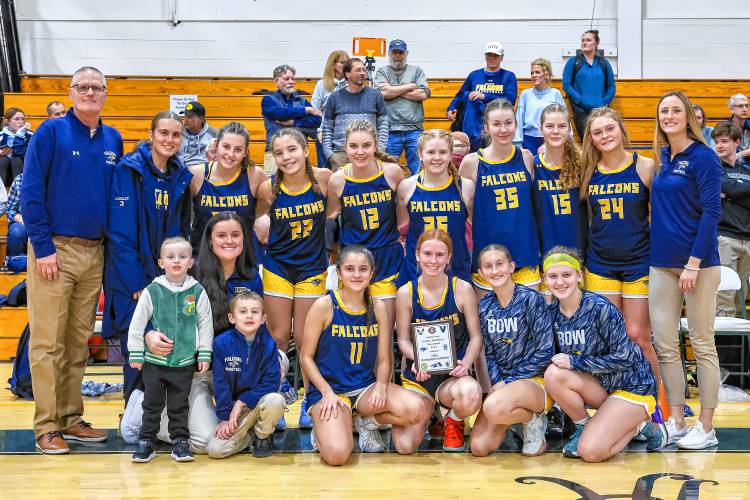 The Bow Falcons girls’ basketball team celebrates with the championship plaque after winning the Capital Classic on Monday. Bow defeated Merrimack Valley, 43-41, in the title game.