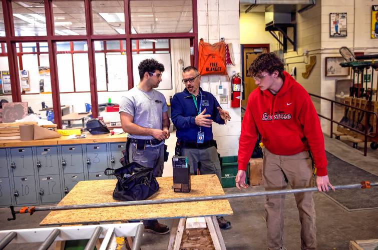 Jesse Gregoire, construction trades teacher at Concord Regional Technical Center (CRTC), talks with student Jeydon Wilson, left, as Bow CRTC student Jake Antuna cleans up a framing project at  Concord High School on Thursday. Gregoire was honored as a Distinguished Educator by the Concord School District in 2024.