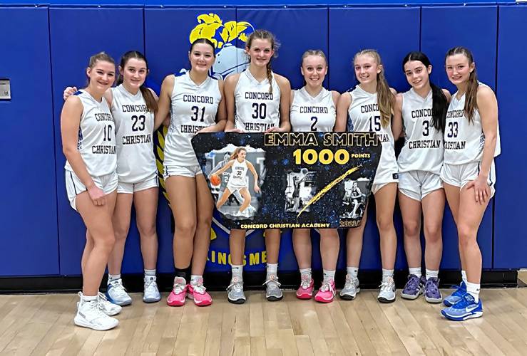 Concord Christian Academy’s Emma Smith (30) and her teammates celebrate with her banner after Smith scored her 1,000th career point in a 53-25 victory over Hanover on CCA's home floor on Friday night. Smith scored 12 points in the victory, including a corner 3 midway through the first quarter to surpass 1,000.