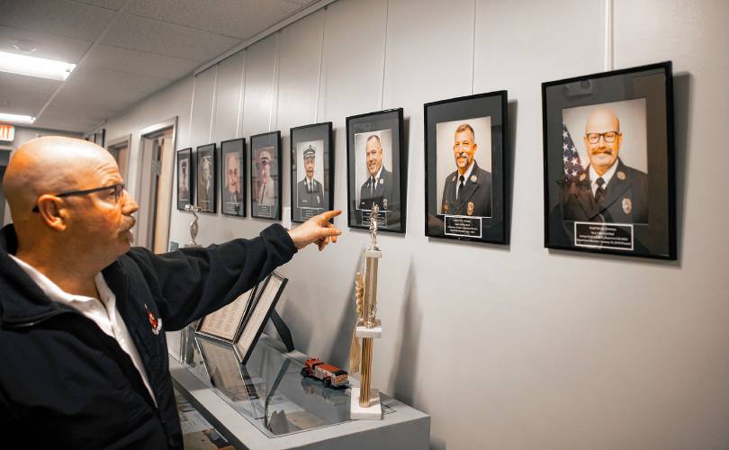 Dennis Comeau looks over the photographs of the Bow fire chief at the central fire station, with his photo allthe way to the right. Comeau was sworn in as Bow’s fire chief in a ceremony on Thursday evening, May 23, 2024. Comeau has been with the Bow Fire Department since 2019, starting out as a firefighter and then becoming a captain.