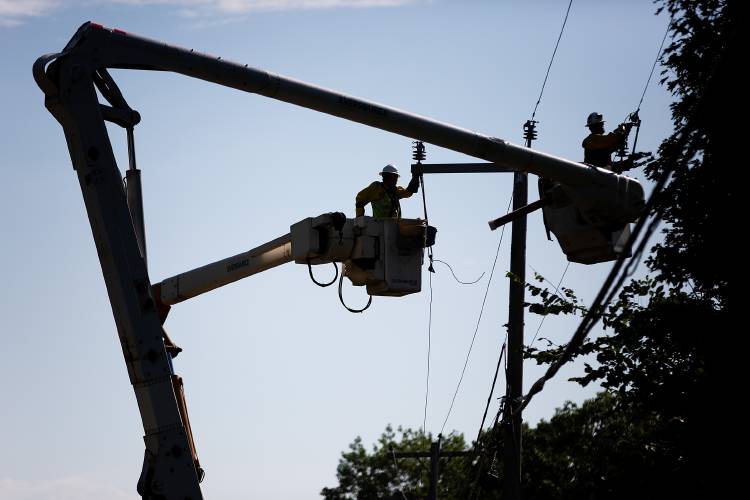 Jake Cote, left, and Nathan Smith, both linemen with Eversource Energy, repair power lines that were knocked down by a storm on Route 10 in Orford, N.H., on Thursday, July 21, 2022. Jake Cote, left, and Nathan Smith, both linemen with Eversource Energy, repair power lines that were knocked down by a storm on Route 10 in Orford, N.H., on Thursday, July 21, 2022.