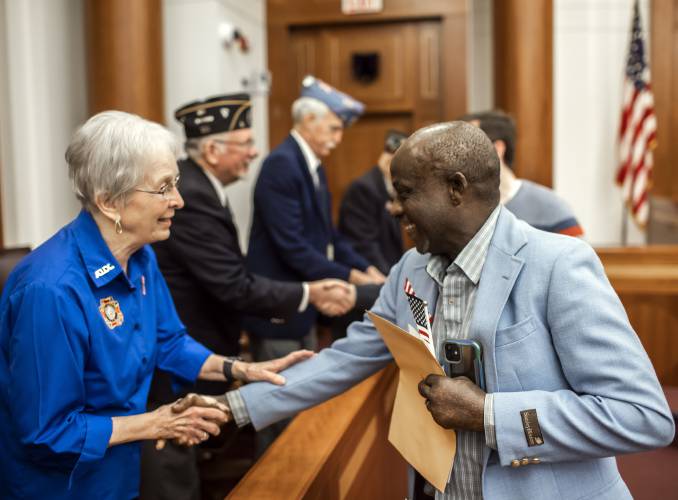 Kayitani Ndutiye is congratulated by VFW Auxilary member Beverley Smith after he was sworn in as a United States citizen, last Friday in a ceremony at the Federal Court in Concord days before the New Hampshire primary.