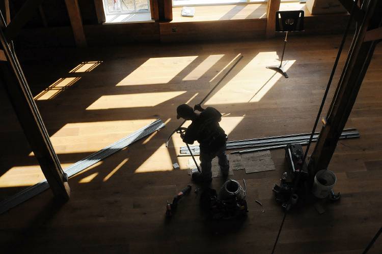 An apprentice electrician bends pipe while installing stage lights in South Pomfret, Vt., in 2014.