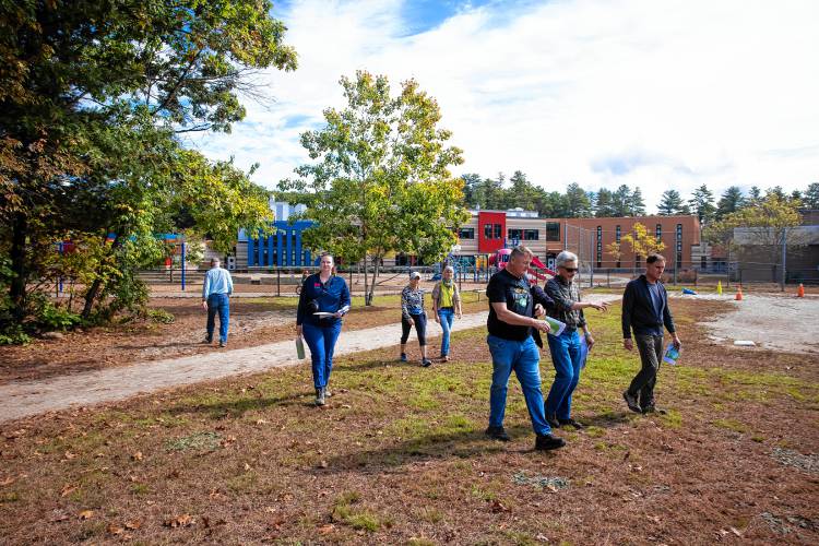 Participants walk around the fields behind Millbrook and Broken Ground schools as they look over the site for the proposed  middle school on Saturday, September 28, 2024.