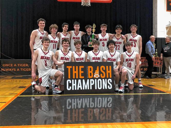 The Coe-Brown Northwood Academy boys’ basketball team celebrates after winning the 45th Annual Mike Lee Holiday Basketball Bash on Monday at Farmington High School. Coe-Brown defeated Belmont, 66-64 in overtime, to win the title.