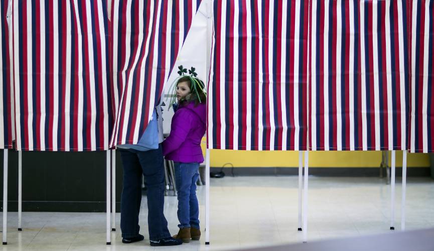 Lyla Scheyd, 6, goes into the voting booth wih her grandmother Joann Scheyd at the St. Johnâs Parish Hall in Allenstown on Tuesday, March 12, 2019.GEOFF FORESTER