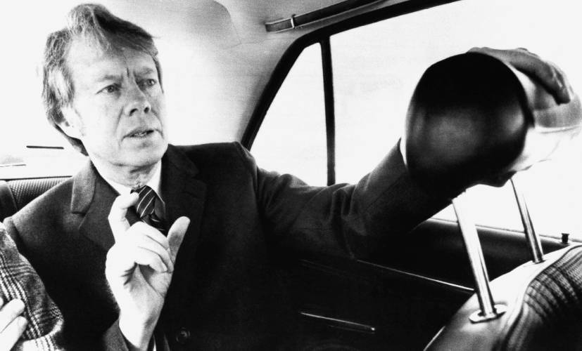 Former Georgia governor Jimmy Carter, who chose the rear seat of a regular car over a staff limousine, talks to reporters on his first trip to Concord on Feb. 14, 1975, while campaigning in the first-in-the-nation primary.