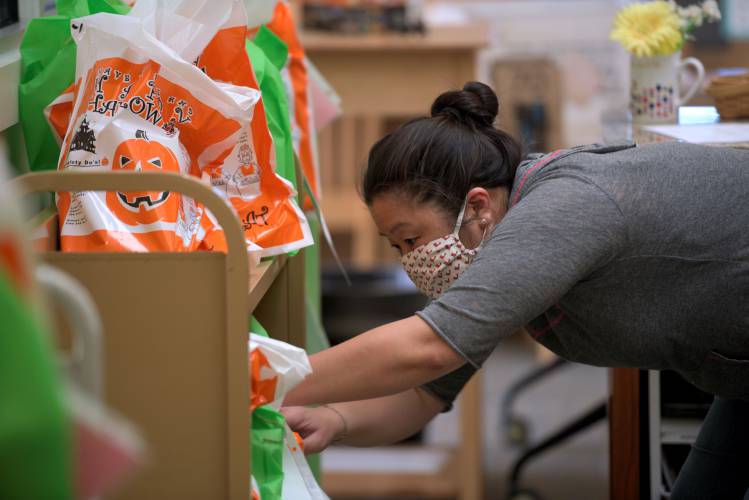 Abbott Library director Mindy Atwood gathers books to be delivered to patrons at home during the COVID-19 pandemic in Sunapee, N.H., on Wednesday, May 13, 2020. (Valley News - James M. Patterson)