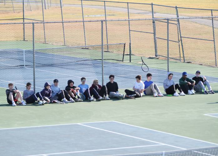 The Concord boys’ tennis team rests and talks while rotating groups do drills to end practice.