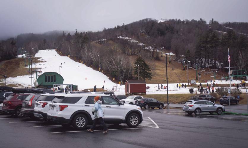 Gunstock Mountain Resort is seen from the newly renovated parking lot, with many trails covered in snow on Friday afternoon. Unseasonably warm weather has made the snow on the trails slushy. 