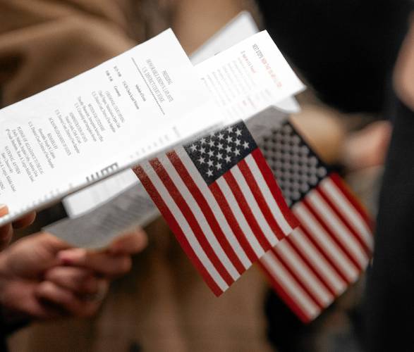 People hold flags during the United States citizen swearing in ceremony at the Federal District Court on Friday, January 19, 2024.