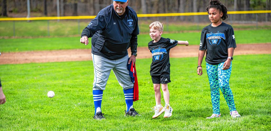 Fred Caruso helps his grandson, Colton, throw out the first pitch with one of his granddaughters, Layla, looking on ahead of Winnisquam's game against Belmont on May 6.