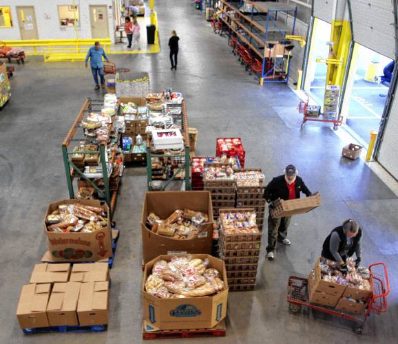In this photo taken Tuesday Oct. 1, 2013 volunteers gather food at the New Hampshire Food Bank in Manchester, N.H. to be delivered around the state.