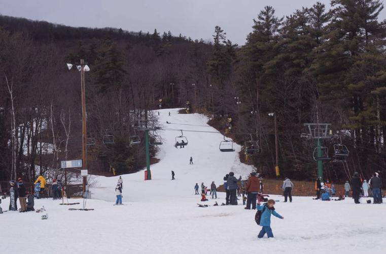 Visitors enjoy their time at Gunstock Mountain Resort in Gilford on Friday afternoon. Unseasonably warm weather has kept snow on the trails slushy.