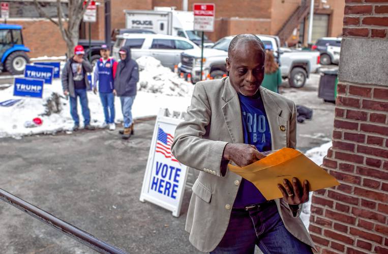 Kayitani Ndutiye looks down on his paperwork as he enters the Green Street Community Center in Concord to vote for the first time in the New Hampshire Primary on Jan. 23.