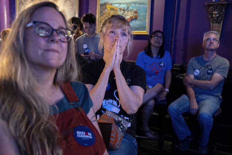 Lori Lahrmann left, and Tonya Morris, second from left, both from Cincinnati, watch the presidential debateThursday at Tillie’s Lounge in Cincinnati. Both plan to vote for President Joe Biden.