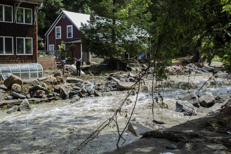 Residents of Plainfield collecting debris after a flash flood hit the Plainfield of Vermont last night, destroying two bridges and plenty of private houses, Thursday, July 11, 2024. (AP Photo/Dmitry Belyakov)