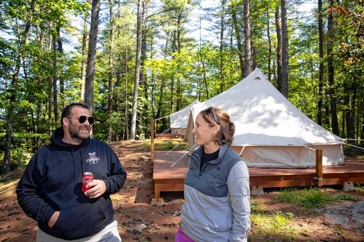 Suncook River Camp’s new owners Joe and Kim Caprio in front of the two platform tents that are available to rent on the property that borders the river in Allenstown.