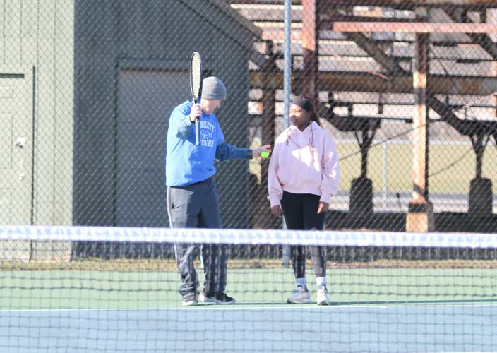 Concord High girls tennis oach Greg Malette, left, helps freshman Faith Chepkoech with her swing during practice at Memorial Field in preparation for the coming season.