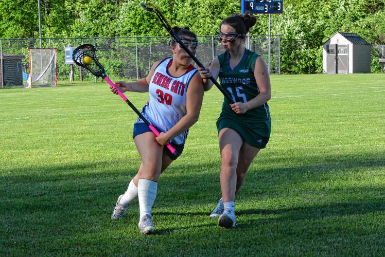 John Stark/Hillsboro-Deering defender Natalie Lawson (left) carries the ball past Kingswood’s Avery Gilpatrick during a Division II girls’ lacrosse first round game in Weare on Tuesday. JSHD won, 12-5, to advance to the quarterfinals.
