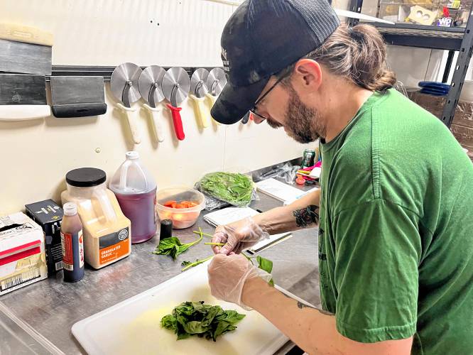 Head chef Mike Ascani picks fresh basil for his Margherita pizza, a new addition to the menu at Vinnie's.