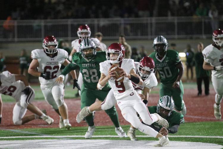 Concord quarterback Colby Nyhan (9) breaks away from the line during a game at Manchester Central last season. Concord won 34-12, its only NHIAA Division I victory of the season. Nyhan is back under center for the Tide this season.