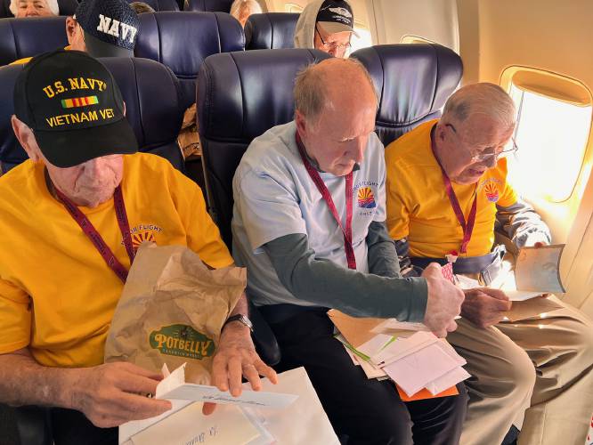 WWII veteran John Dianis (left) participated in an honor flight in mid-April, 2025. His son, Jack Dianis (middle), presented him with the Concord letters on the plane back to Arizona.