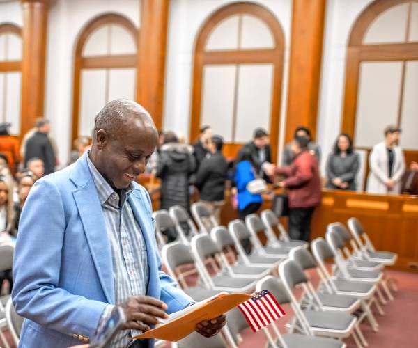 Kayitani Ndutiye looks down on his paperwork after he was sworn in as a United States citizen last Friday in a ceremony at the Federal Court in Concord, days before the New Hampshire primary.