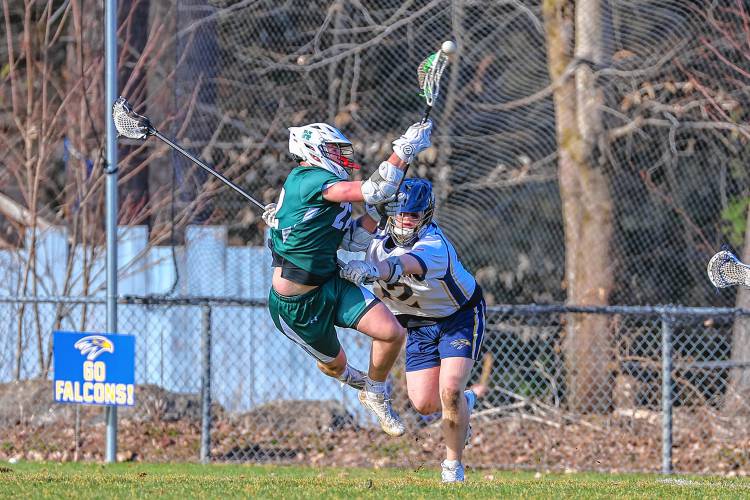 Hawks freshman Jackson Westover fires a shot on net as he’s checked by Bow’s Eli Ayers on Tuesday.