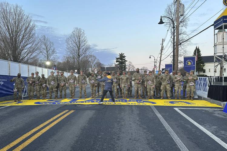Boston Marathon Race Director Dave McGillivray, centre, sends a group of Massachusetts National Guard members across the start line in Hopkinton on Monday, April 15, 2024 to begin the marathon. The start line was painted in honor of the town that has hosted the marathon for the past century. It's the 128th edition of the world’s oldest and most prestigious annual marathon. (AP Photo/Jennifer McDermott)