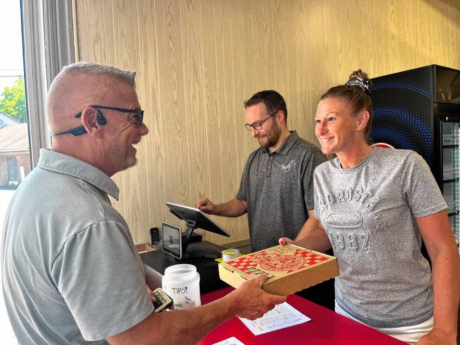 Lauren Potvin and Greg Tandy sold a slice of pizza to local realtor Pete Duval.