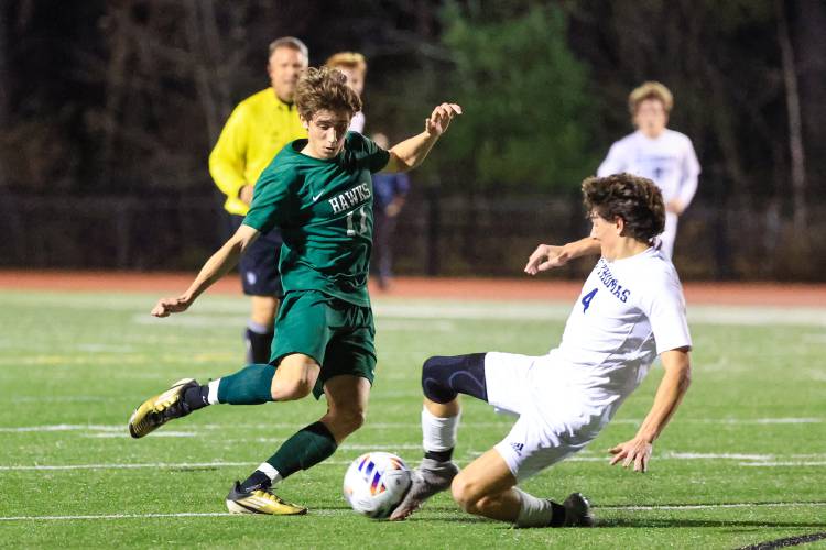 Saint Thomas’ junior midfielder Aidan Molt (4) dispossesses Hopkinton’s senior midfielder Deegan Tomaz (10) with a slide tackle in Wednesday’s semifinal at Bedford High School.