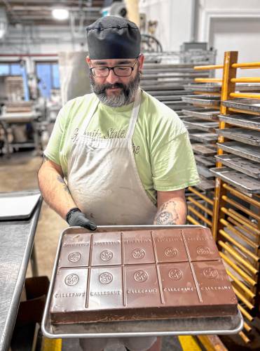 Chocolatiers at the Granite State Candy Shoppe factory on Hall St. Concord prepared chocolates for Valentine's Day on Monday, Feb. 3. Ed Brand held an eleven-pound bar of chocolate that he planned to melt into chocolate for coating candies.