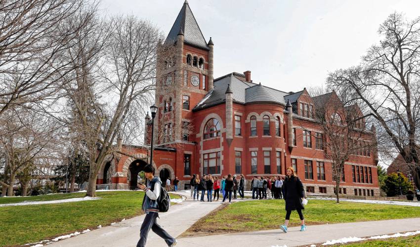 In this photo taken Wednesday April 6, 2016 students walk past the historic Thompson Hall at the University of New Hampshire in Durham, N.H. (AP Photo/Jim Cole)