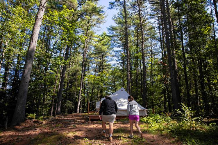 Suncook River Campâs new owners Joe and Kim Caprio in front of the two platform tents that are available to rent on the property that borders the river in Allenstown.