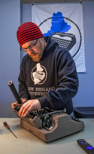 Store owner Matt Snyder works on a manual typewriter at New England Typewriter in Merrimack on Saturday, November 16, 2024. Snyder opened it to sell and service devices that are decades old.