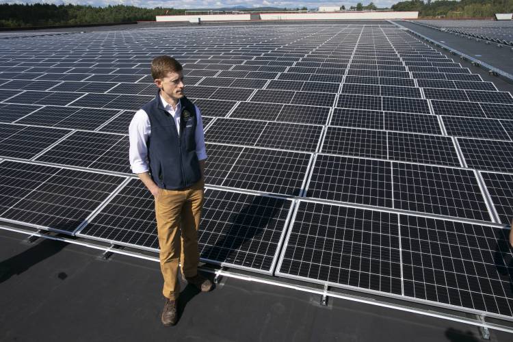 ReVision co-owner Dan Weeks stands in front of the largest rooftop solar array in New Hampshire at the Associated Grocer of New England warehouse facility in Pembroke in 2021.