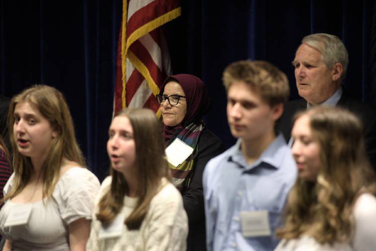 Judge Anisa Rasooli, center, Paul Reiber, chief justice of the Vermont Supreme Court, right, listen to the Hanover High School chorus sing the Star Spangled Banner.