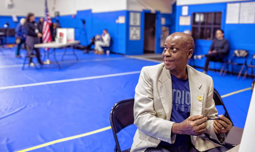 Kayitani Ndutiye gets help with translations as he registers to vote for the first time in the United States at the Green Street Community Center on Primary Day in New Hampshire.