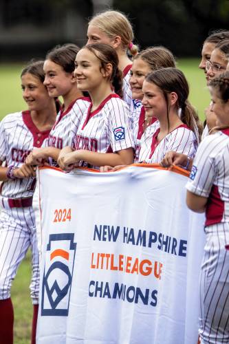 The Concord Little League team holds up the championship banner during a ceremony and practice at Rollins Park on Tuesday.