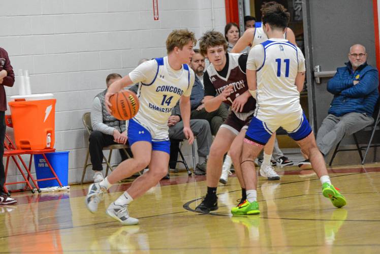 Concord Christian Academy’s Jaden Young (14) dribbles around a pick set by teammate Logan Duffy (11) during the Division IV boys’ basketball semifinal at Laconia High School on Monday. No. 2 Concord Christian fell to No. 3 Littleton, 64-51, CCA’s first loss of the season.
