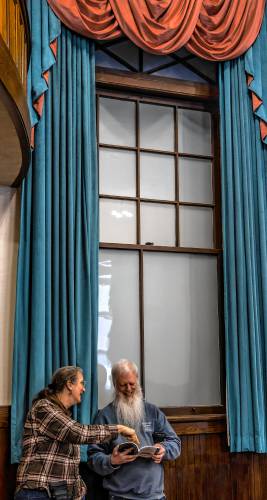 Mary and Dan Watts look over the Warner annual report during the town meeting on Wednesday, March 12, 2025.