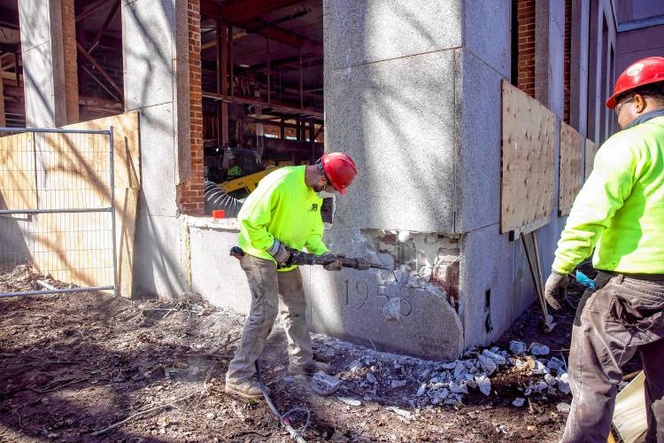 Members of the S&R Demolition team out of Lowell, Massachusetts use an hammer to chip away at the cornerstone of the former DOJ and Mechanics Bank building on North State Street as they search for the time capsule on Tuesday, April 9, 2024.