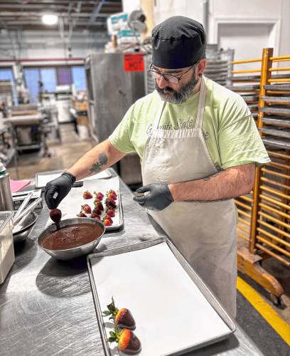 Chocolatiers at the Granite State Candy Shoppe factory on Hall St. Concord prepared chocolates for Valentine's Day on Monday, Feb. 3. Ed Brand, who has worked at the company for eight years, dipped strawberries in chocolate.