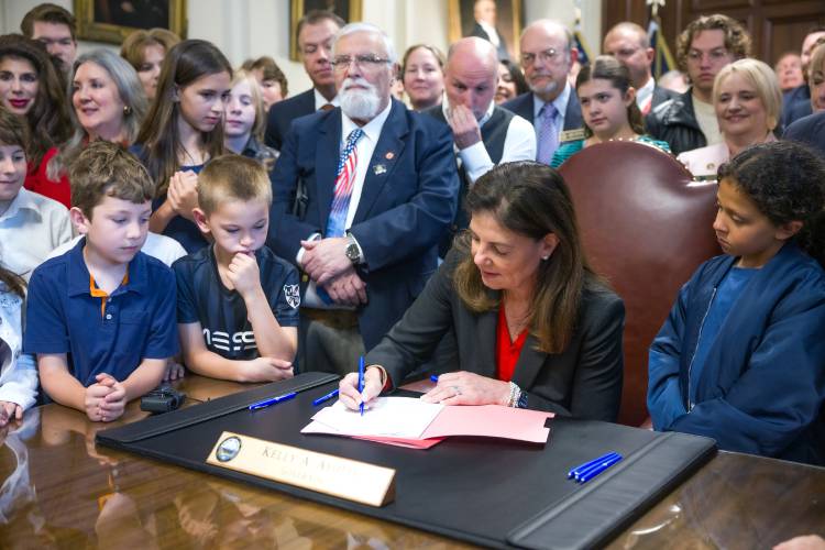 Surrounded by children and state legislators, Governor Kelly Ayotte signs the Parental Rights HB 10 bill at the Executive Council chambers on Tuesday, June 10, 2025.