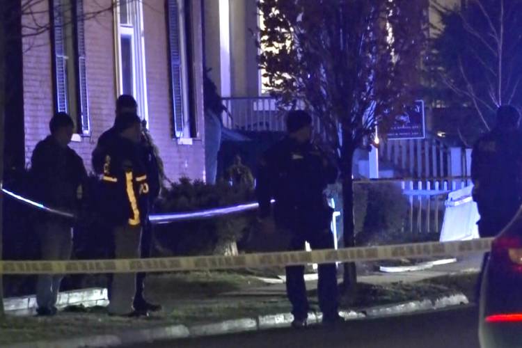 In this still frame from video provided by WCAX-TV law enforcement officers stand by police tape near a scene Saturday, Nov. 25, 2023 where three men of Palestinian descent were shot and injured, in Burlington, Vt. Burlington Police Department arrested Jason J. Eaton, suspected in the shooting of three young men, who were attending a Thanksgiving holiday gathering near the University of Vermont campus Saturday evening. (WCAX-TV via AP)