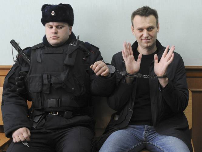 FILE - Russian opposition leader Alexei Navalny, right, poses for press as he sits handcuffed in court in Moscow, Russia on March 30, 2017. Russia’s prison agency says that imprisoned opposition leader Alexei Navalny has died. He was 47. The Federal Prison Service said in a statement that Navalny felt unwell after a walk on Friday Feb. 16, 2024 and lost consciousness. (AP Photo, File)