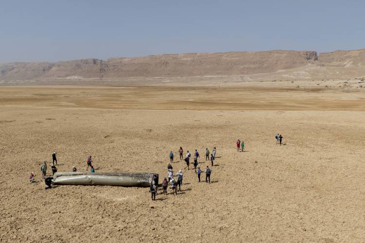 People gather around a component from an intercepted ballistic missile that fell near the Dead Sea in Israel, Saturday, April 20, 2024. Open fighting between Israel and Iran began April 1 with the suspected Israeli killing of Iranian generals at an Iranian diplomatic compound in Syria. People gather around a component from an intercepted ballistic missile that fell near the Dead Sea in Israel, Saturday, April 20, 2024. Open fighting between Israel and Iran began April 1 with the suspected Israeli killing of Iranian generals at an Iranian diplomatic compound in Syria.