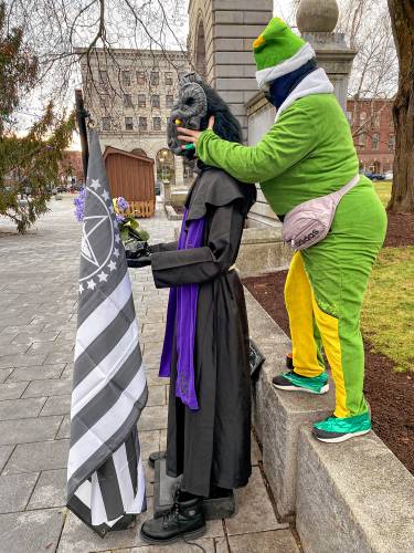 A volunteer dressed as an elf rebuilt the statue of Baphomet outside the State House Wednesday after it was vandalized for the second time in as many weeks.