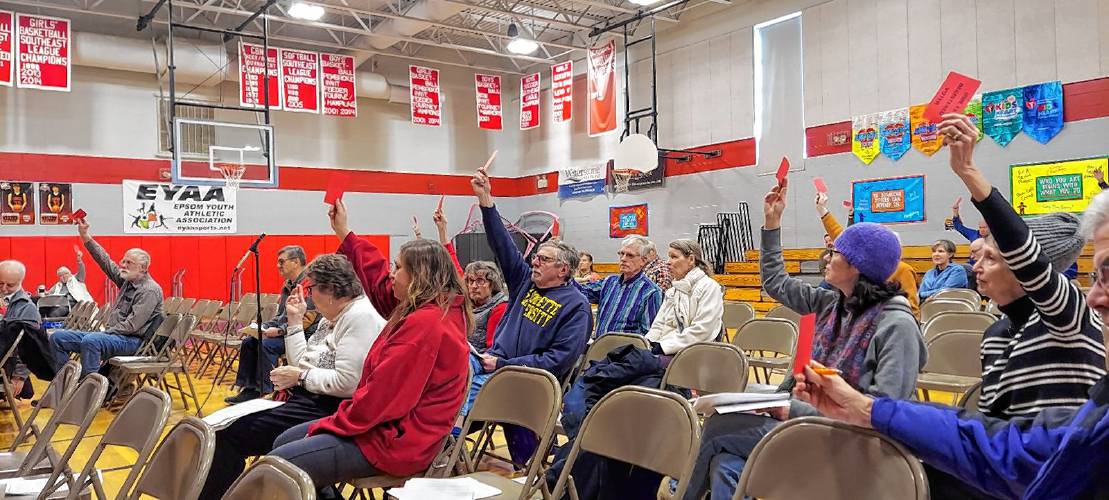 Epsom residents raised their cards to reject an amendment to cut $10,000 from a request to add $25,000 into an account for future bridge repairs. 